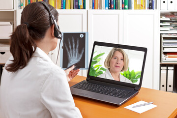 Telemedicine concept: two doctors or pharmacists during a medical video conference about x-ray...