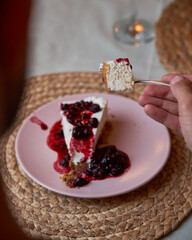 Unrecognizable man eating delicious homemade cheesecake served as dessert in an elegant Italian restaurant. Food and lifestyle concept