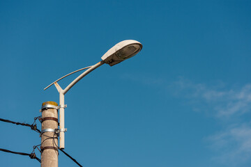 High street light on a pillar in daytime against a clear blue sky