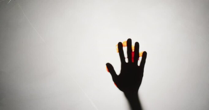 Video of silhouette of hand with blood stains moving on white background