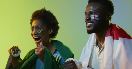 Video of joyful african american female and male sport fans with flags of england and portugal - Powered by Adobe