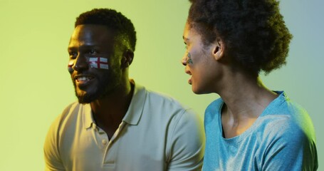 Video of joyful african american female and male sport fans with flags of england and portugal - Powered by Adobe