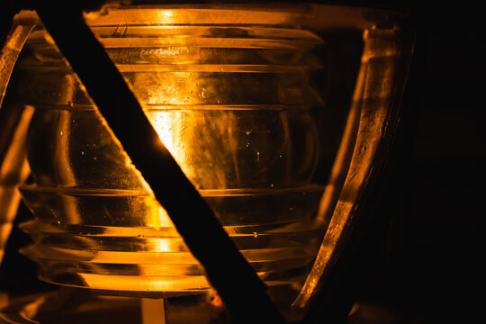 Yellow lamp glows in metal frame, closeup photo