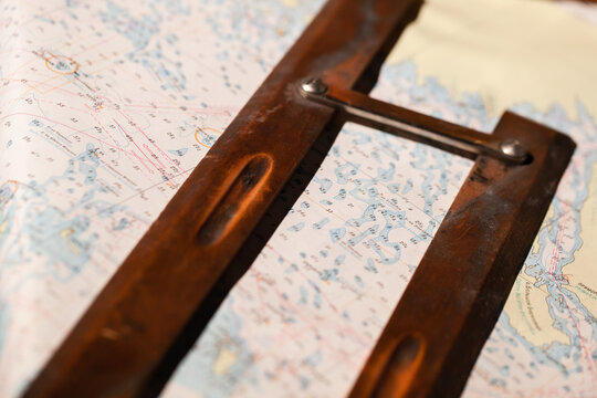 Vintage wooden parallel ruler lays on a nautical chart