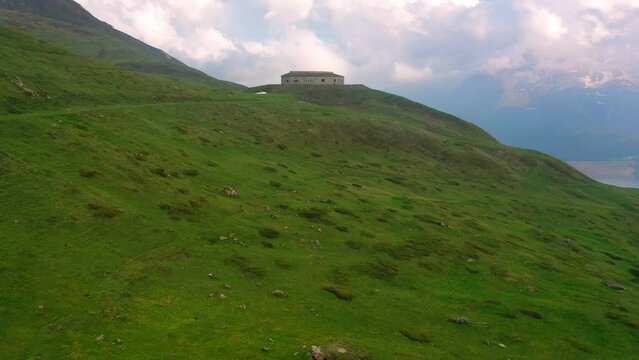 Aerial Forward Shot Of Fort De Ronce On Green Hill By Lake - Val-Cenis, France