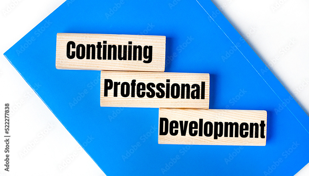 Poster there is a blue notebook on a light gray background. above are three wooden blocks with the words cp