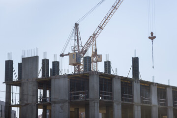 Fototapeta na wymiar Multi-storey apartment building is being constructed using tower cranes that can reach heights as the work progresses along the building