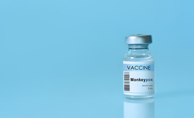 Vial with vaccine Monkeypox on a blue background.The concept of medicine, healthcare and science.Monkeypox is a viral zoonotic disease. Monkeys may harbor the virus and infect people.Copy space