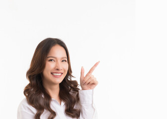 Asian woman with long hair wearing a white shirt is smiling and pointing her finger in the white copy space.