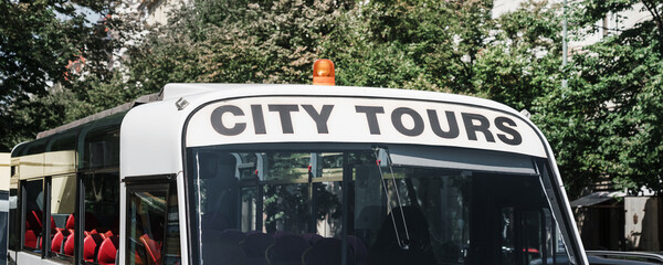 City tour inscription on excursion bus at city street. Sightseeing and traveling.