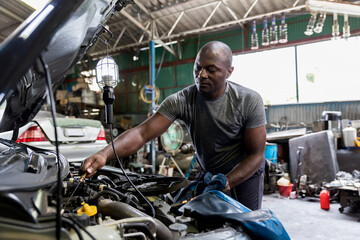 Fototapeta na wymiar Car mechanic checking oil quality the engine motor car Transmission and Maintenance Gear. car mechanic in an auto repair shop is checking the engine.