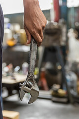 Wrench in Hand of car mechanic. Hand holding a metal Wrench