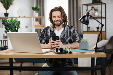 Happy smiling businesswoman using modern smartphone for video chat at work. Young caucasian female sitting at modern bright office. Technology concept.