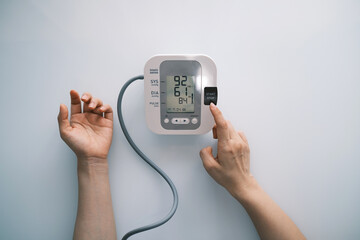 Adult woman measuring blood pressure at home