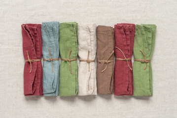 Set of linen napkins lay flat on a beige textile background. Top view. Colorful napkin.