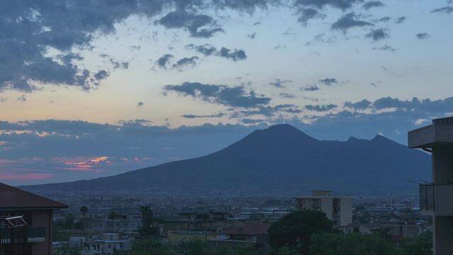 Angri, Italy. View of the south-east side of Mount Vesuvius at sunset with the town of Angri and its residential buildings in the foreground. Video Time Lapse. June 04, 2020.