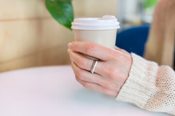 Paper coffee cup in a female hand. Coffee to go. walks in the open air.