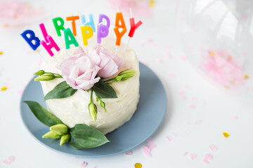Very beautiful bright bento cake, decorated with fresh eustoma flowers against the background of sweets and the inscription happy birthday, balloons. The concept of holiday and smiles.