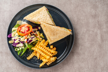 Tuna sandwich with french fries and salad.