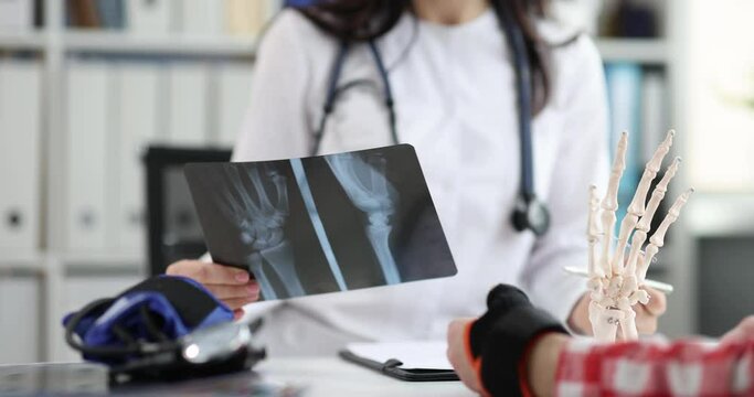Doctor examined patient with pain in wrist and x-ray of hand