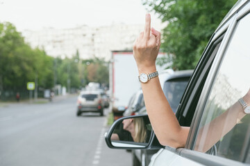 Woman driving a car showing middle finger. Angry woman demonstrating fuck you off sign from open window. - obrazy, fototapety, plakaty