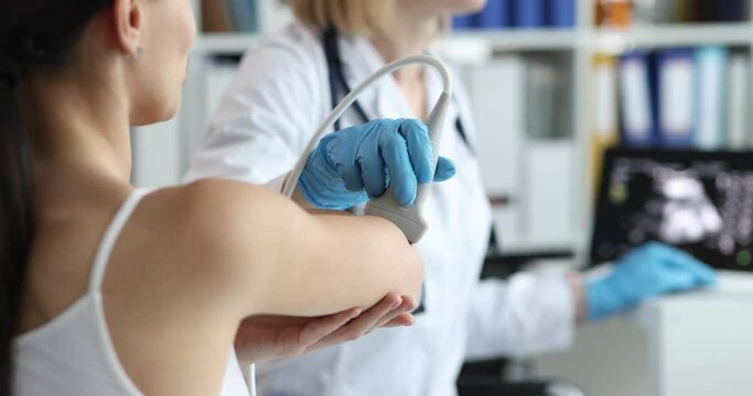 Medical device examines elbow joint of woman on medical ultrasound