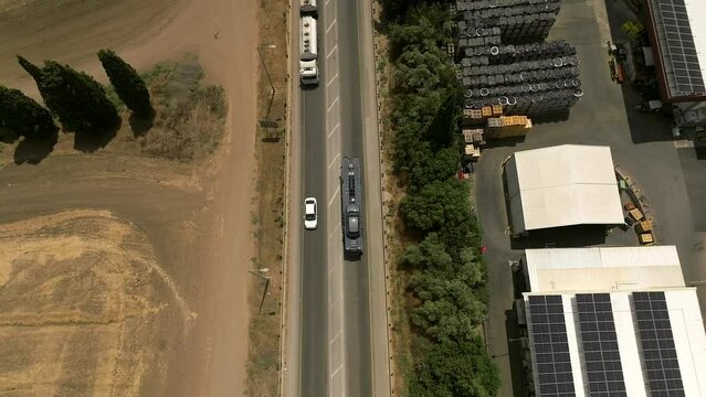 Tow truck carrying a single car on a rural highway, Aerial follow footage.
