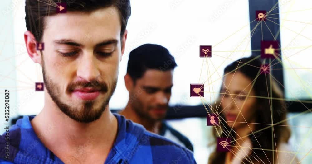 Poster animation of two globes of digital icons over caucasian man smiling while using smartphone at office