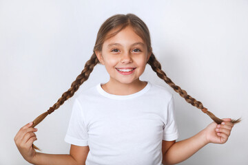 Portrait of nice funny cheerful positive pre-teen girl wearing white t-shirt having fun on white background