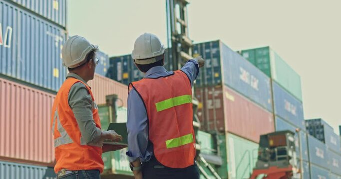 Businessmen and transport worker are Negotiate transportation business in warehouse Container port. engineer consulting with team with professional. Business cooperation agreement