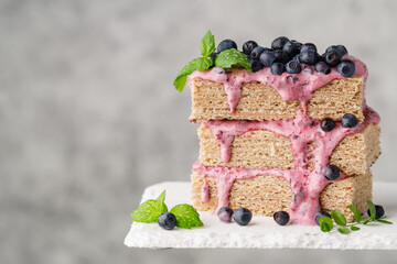 waffle cake with blueberries and mint on a light gray background