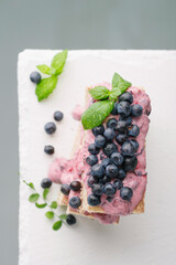 waffle cake with blueberries and mint on a light gray background