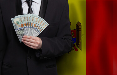 Moldavian man with 100 US dollar bills money banknotes against flag of Moldova background