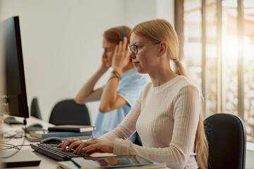 Focused university student using computer studying in computer room