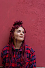 Portrait of young woman with red dreadlocks wearing a red checkered shirt