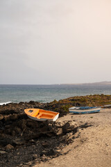 Fototapeta na wymiar Two small fishing boats on the shore at sunset