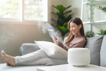 Obraz na płótnie Canvas Air Humidifier Device At home and Woman relaxing on the sofa