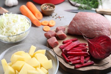 Fresh ingredients for borscht on grey table, closeup