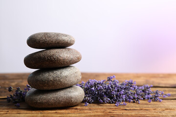 Fototapeta na wymiar Lavender flowers and spa stones on wooden table. Space for text