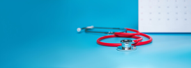 Calendar, stethoscope, on a blue background, health care concept.