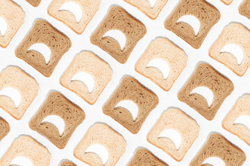 Moody emoji pattern made of slices of white and brown whole grain toast bread on isolated pastel...