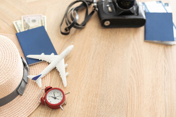 Preparation for Traveling concept, watch, tickets, money, passport, airplane on a vintage wooden background with copy space.