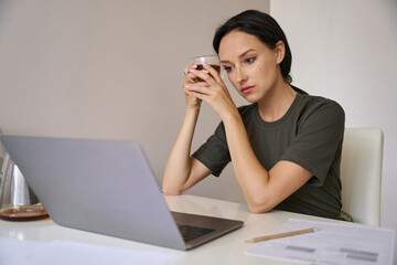 Woman with a cup of tea at the laptop