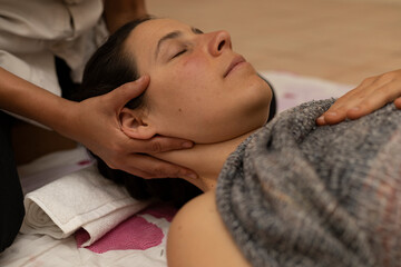 Latina woman receiving a Shiroadhyanga massage on the face with specific pressure points