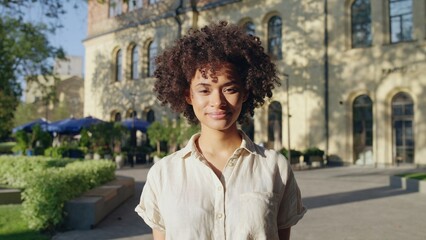 Attractive African American woman smiling, standing on street, female tourist