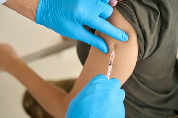 Nurse giving an injection to the arm of a young woman