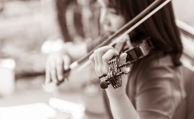 Blurred soft images of an Asian woman playing violin, to people and musician concept.