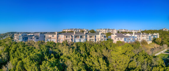 Fototapeta premium Austin, Texas- Large residential buildings on top of a mountain with trees on the slope