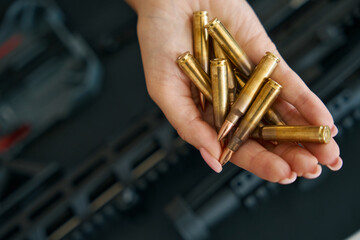 Obraz premium Combat cartridges on a tender female palm