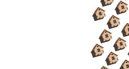 Pattern made with wooden house on white background. Mortgage, investment, real estate, property and new home concept.
